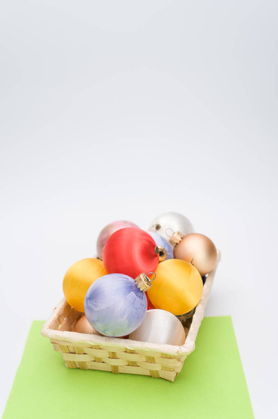 Multicolored Christmas decorative balls in a wicker canister with sapce for text - Fotoğraf, Görsel