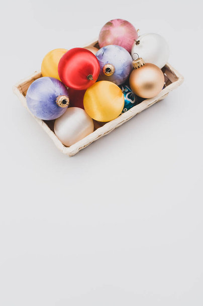 Multicolored Christmas decorative balls in a wicker canister with sapce for text - Фото, зображення