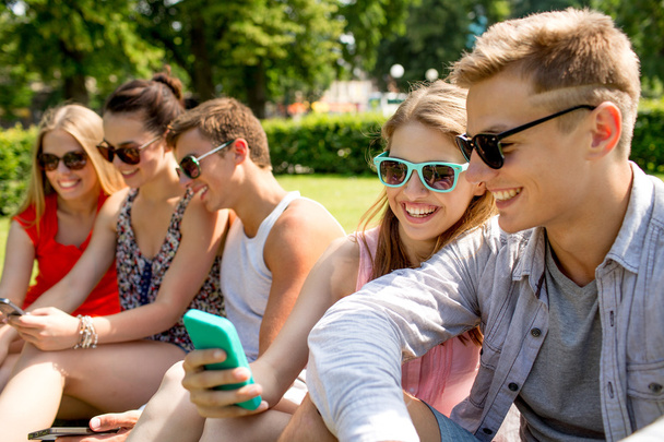 smiling friends with smartphone making selfie - Foto, imagen