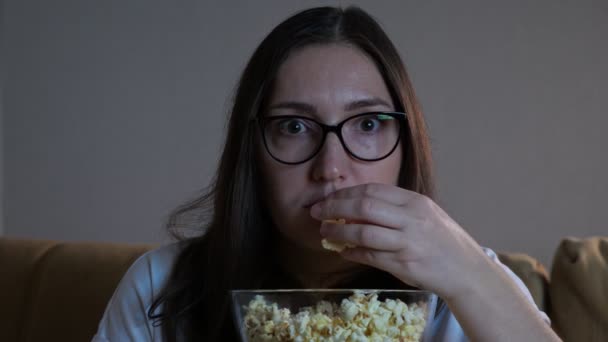 Signora con la faccia spaventata mangia popcorn guardando film spaventoso - Filmati, video