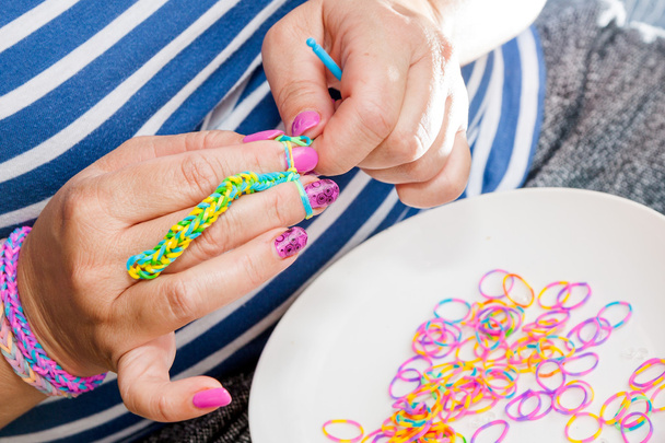 Жінки з барвистими цвяхами роблять гумовий ткацький верстат
 - Фото, зображення