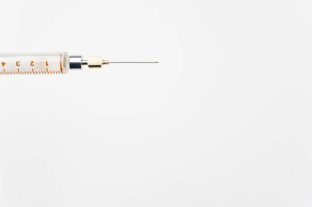 egy különálló injekciós fecskendő fehér papíralapon, szövegrésszel - Fotó, kép