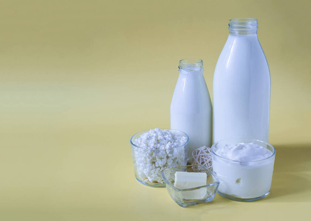 A set of dairy products on a yellow background of the mine space. Milk, kefir, sour cream, butter and cottage cheese on a light background close-up - Φωτογραφία, εικόνα