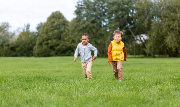 happy little boys running at park - 写真・画像