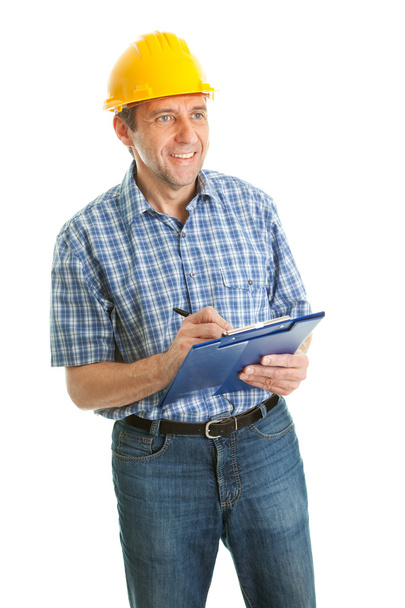 Worker wearing hard hat and taking notes - Photo, image