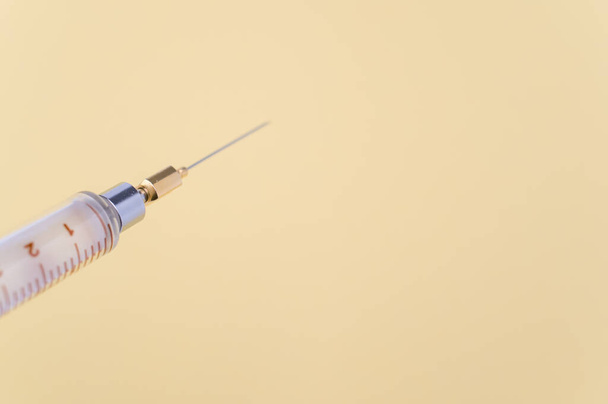 an isolated injection syringe on yellow paper background with text space - Φωτογραφία, εικόνα