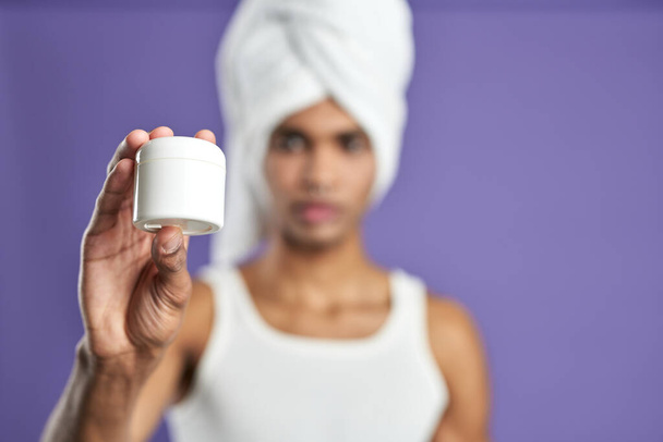 Attractive male show cream in hand bokeh portrait. Young african american man in white towel, t-shirt - Φωτογραφία, εικόνα