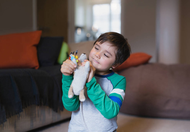 Portrait enfant heureux garçon jouant avec jouet pour chien dans le salon, jeune enfant positif s'amusant à jouer avec ses jouets se détendre à la maison après le retour de l'école - Photo, image