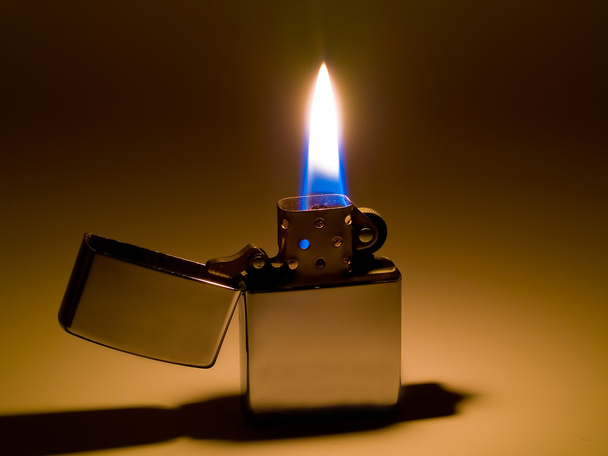 A cigarette lighter with a yellow and blue flame - Photo, Image