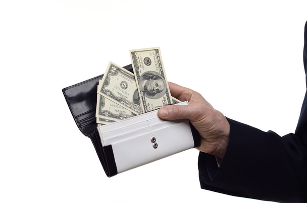 χέρι που κρατά το λογαριασμούς δολαρίων σε ένα πορτοφόλι σε άσπρο φόντο - Φωτογραφία, εικόνα