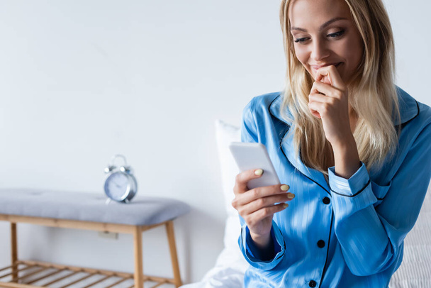 happy woman in pajamas talking on smartphone in bedroom  - Foto, imagen