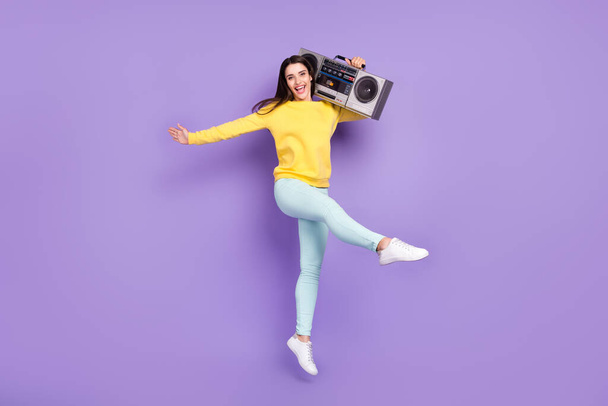 Full size photo of cheerful pretty happy woman jump up hold hands boombox isolated on purple color background - Valokuva, kuva