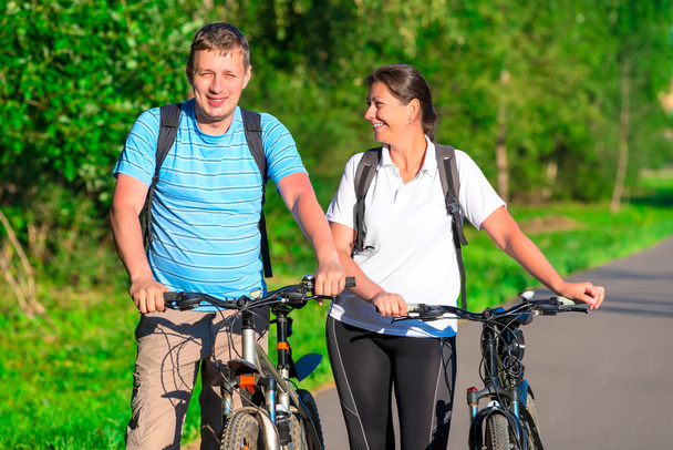 pareja montando en bicicleta en un parque por la mañana
 - Foto, imagen