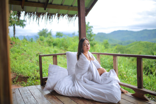Mulher asiática cobrindo um cobertor branco na vista da natureza das montanhas com selva verde - Foto, Imagem