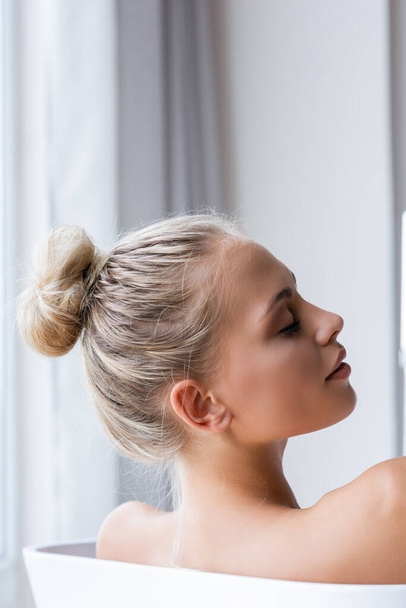young blonde woman with closed eyes taking bath  - Zdjęcie, obraz