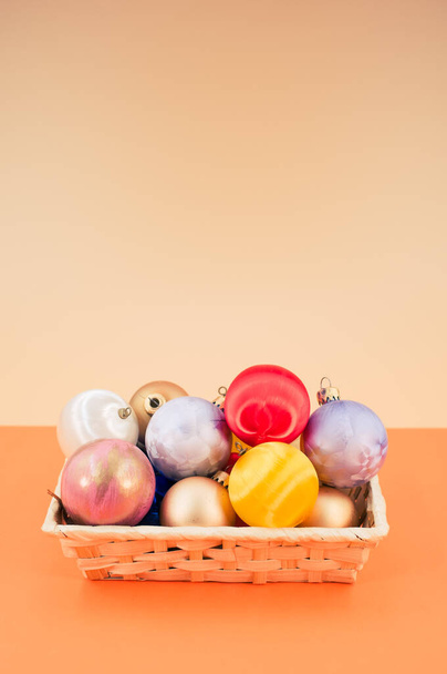Multicolored Christmas decorative balls in a wicker canister with sapce for text - Fotoğraf, Görsel