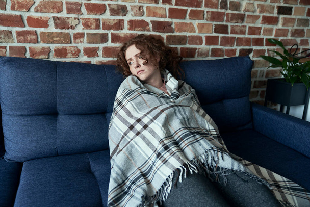 Deprimido jovem caucasiano mulher piso em silêncio ao lado do sofá - Foto, Imagem