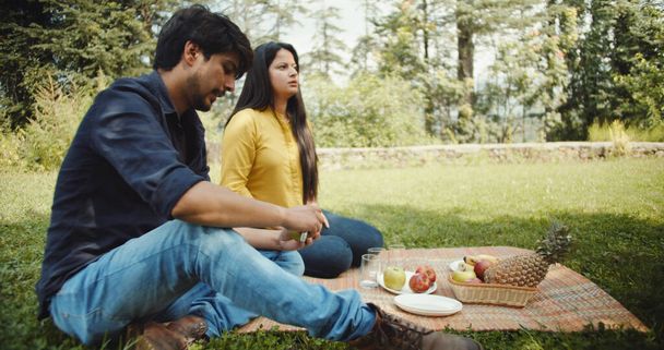 A young Indian couple on a picnic, outdoors in a park - Foto, Imagem