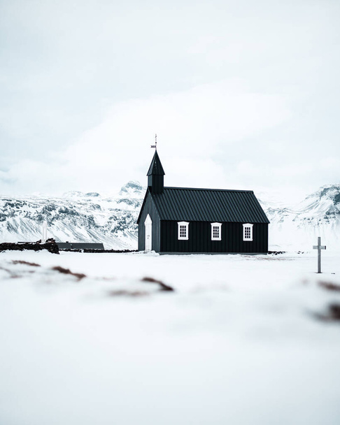Bakirkja, Snfellsnes Peninsula, Iceland, Black church surrounded by snow, frozen nature and mountains - Photo, Image