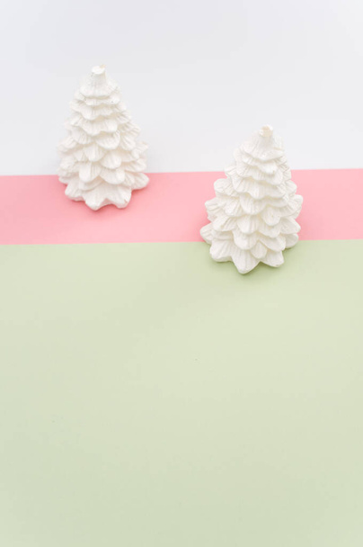 Christmas ornamental background with fir trees on a pink and green surface with copy space - Photo, image