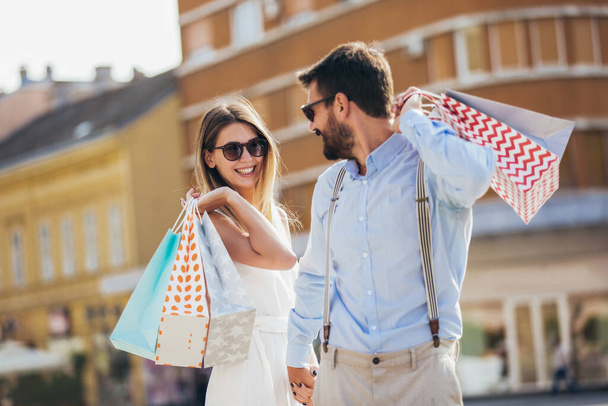 Όμορφο ζευγάρι απολαμβάνει ψώνια μαζί στην πόλη. - Φωτογραφία, εικόνα