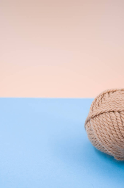 A vertical shot of isolated beige yarn on blue background with text space - Foto, Imagem