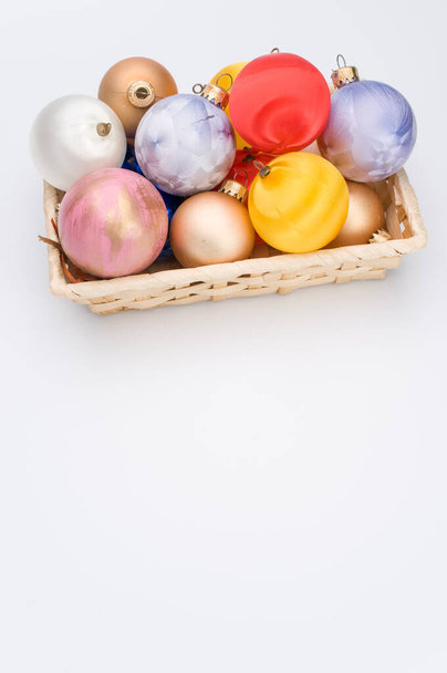 Multicolored Christmas decorative balls in a wicker canister with sapce for text - Foto, Imagen