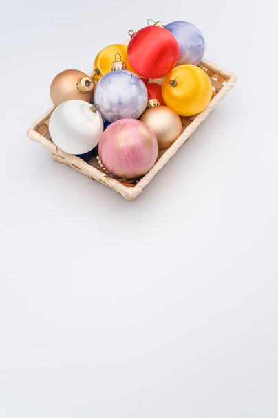 Multicolored Christmas decorative balls in a wicker canister with sapce for text - Foto, immagini