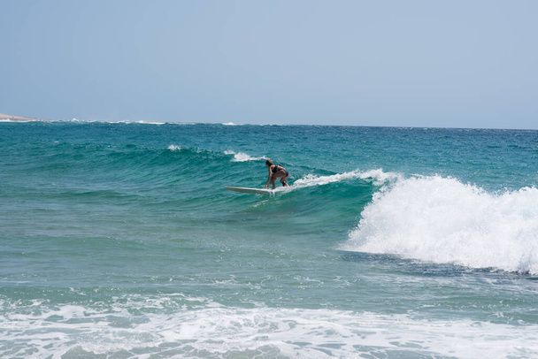 Femme vu équitation vague avec sa planche de surf - Photo, image