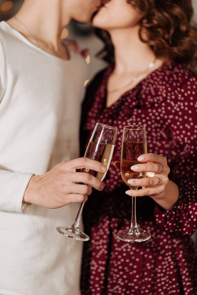stylish man and woman holding glasses of champagne and kissing - Fotó, kép