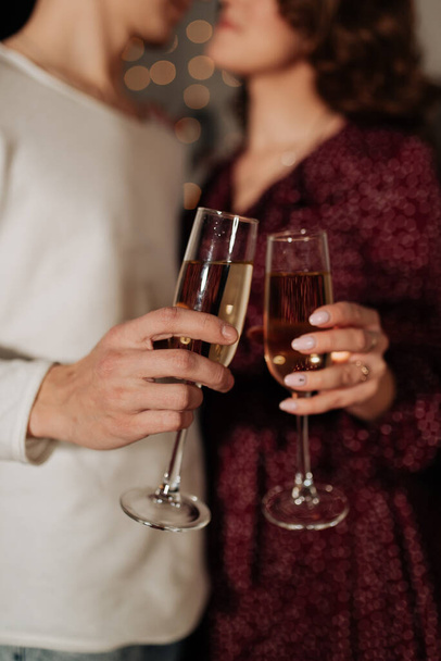 glasses with champagne close-up in the hands of a stylish young couple - Fotó, kép