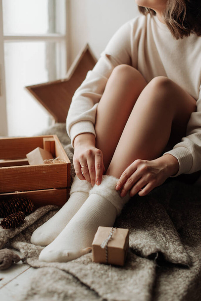 beautiful naked female legs in white socks girl sitting on the bed - Foto, Imagen