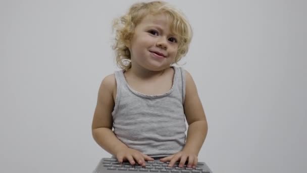 Маленькая девочка печатает на клавиатуре - Кадры, видео