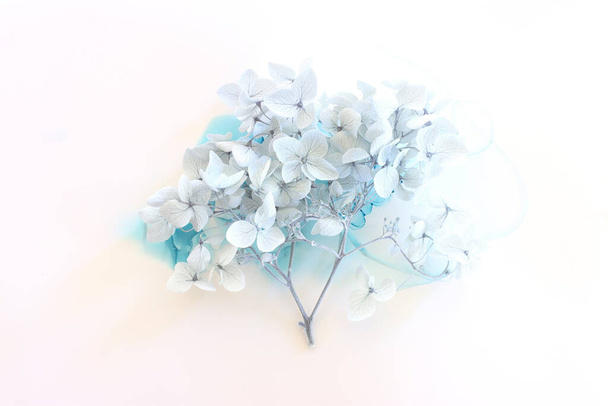 Creative image of pastel blue Hydrangea flowers on artistic ink background. Top view with copy space - Фото, изображение