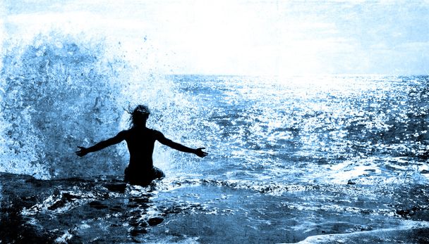oceán vln stříkající na muže, který seděl na skále - Fotografie, Obrázek
