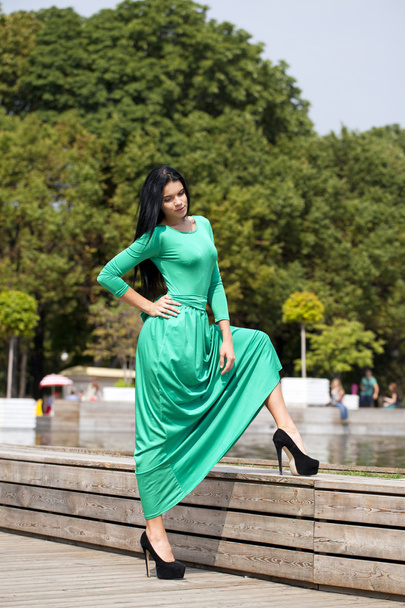 Beautiful young woman in green long dress - Фото, изображение