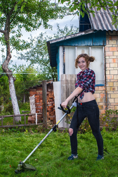 Frau im karierten Hemd beim Rasenmähen - Foto, Bild