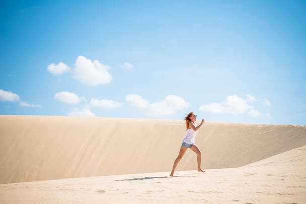Young woman running on dunes - Fotó, kép