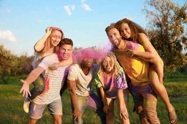 Happy friends covered with colorful powder dyes outdoors. Holi festival celebration - Φωτογραφία, εικόνα