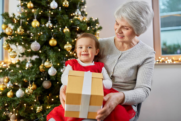 grandmother and baby girl with christmas gift - Foto, Imagem