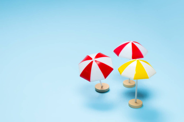Žlutý a červený deštník na modrém pozadí. Kopírovat prostor. - Fotografie, Obrázek