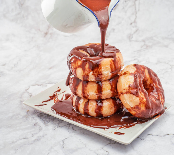 Primer plano de donuts de azucar baados con chocolate sobre una mesa   - Foto, imagen