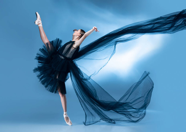 Young and graceful ballet dancer in black stage outfit, dress isolated on white blue studio background in neon light. - Foto, Bild