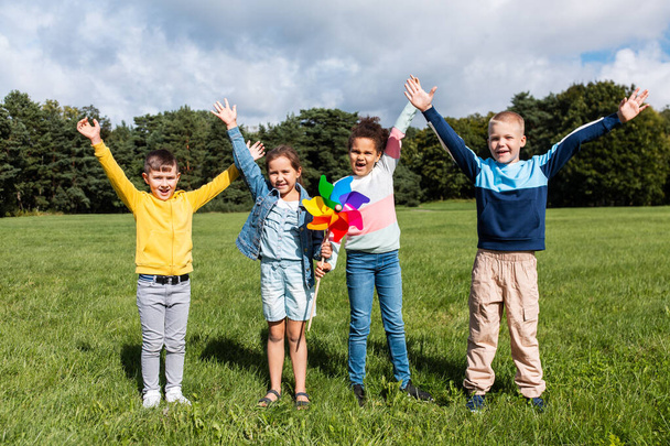 happy kids with pinwheel having fun at park - Fotografie, Obrázek