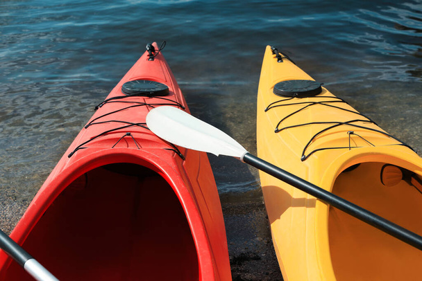 Modern kayaks with paddle on river, closeup. Summer camp activity - Fotografie, Obrázek