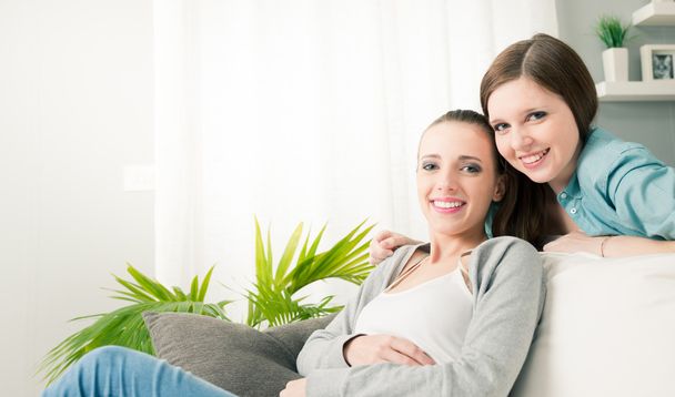 Smiling girlfriends in the living room - Foto, afbeelding