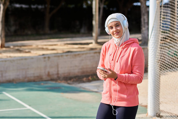 Moslim jonge vrouw met koptelefoon nemen van een pauze - Foto, afbeelding
