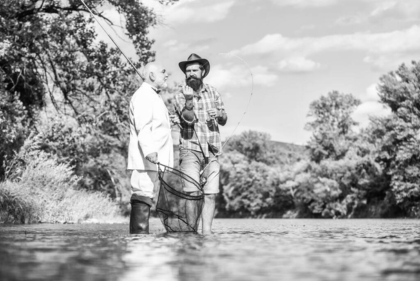 Fishing is not boring for me. friends men with fishing rod and net. happy fishermen. Good profit. hobby of businessman. retirement fishery. Fly fishing adventures. retired dad and mature bearded son - Photo, image