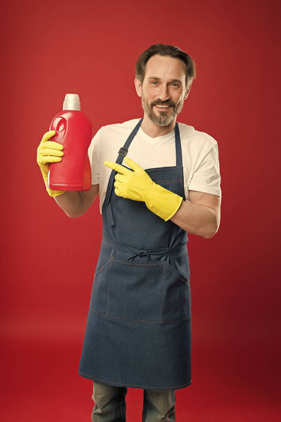 Try this. Product for cleaning. Cleaning service. Household duty. Man rubber gloves hold plastic bottle liquid soap chemical cleaning agent. Bearded guy cleaning home. Cleanup concept. Doing laundry - Photo, Image