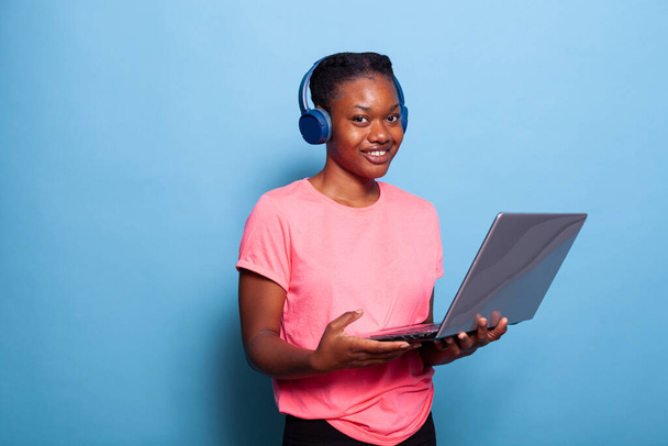 Portrét usměvavé africké americké studentky s sluchátky poslech hudby - Fotografie, Obrázek